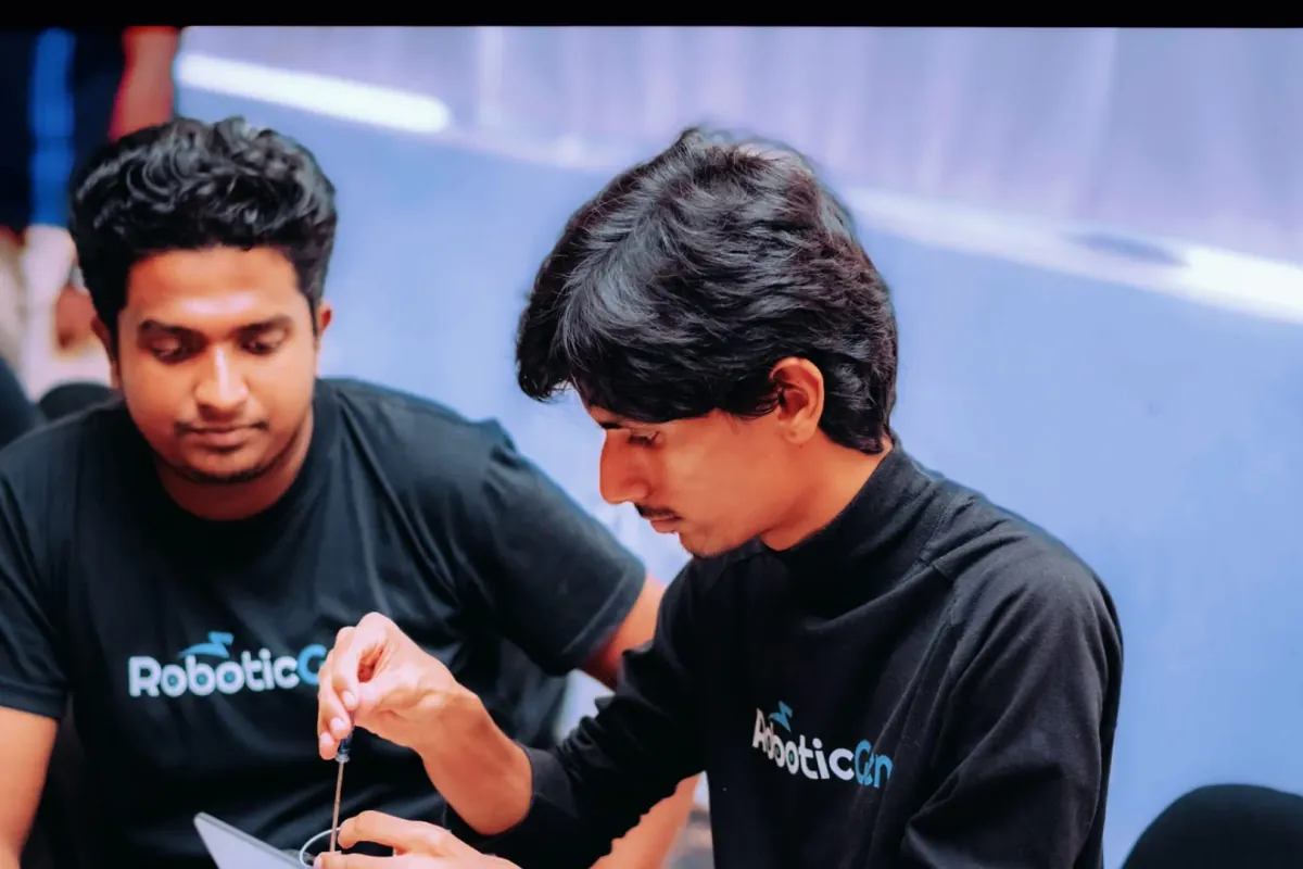 Two RoboticGen engineers soldering a circuit board together.